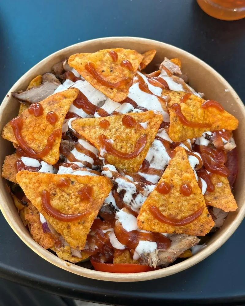 Nacho bowl topped with chips with ketchup smiley faces at Wrap Up