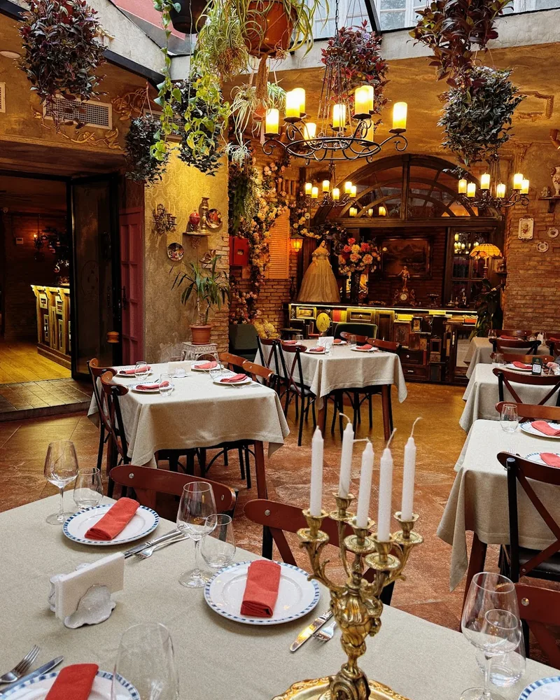 Dining room with candelabras and hanging plants at Zala Restaurant & Cellar